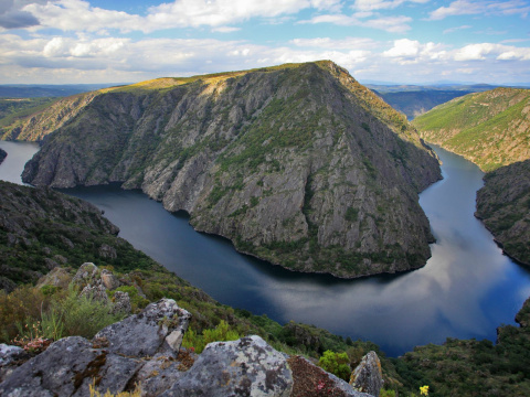 Vista panorámica del Cañón del Sil en la Ribeira Sacra, con el río rodeando montañas escarpadas y vegetación.