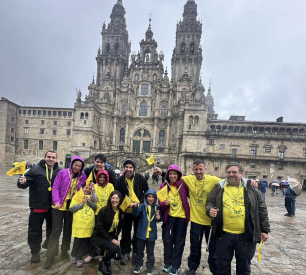 Peregrinos caminando el Camino de Santiago en grupo con perro y apoyo logístico en camper