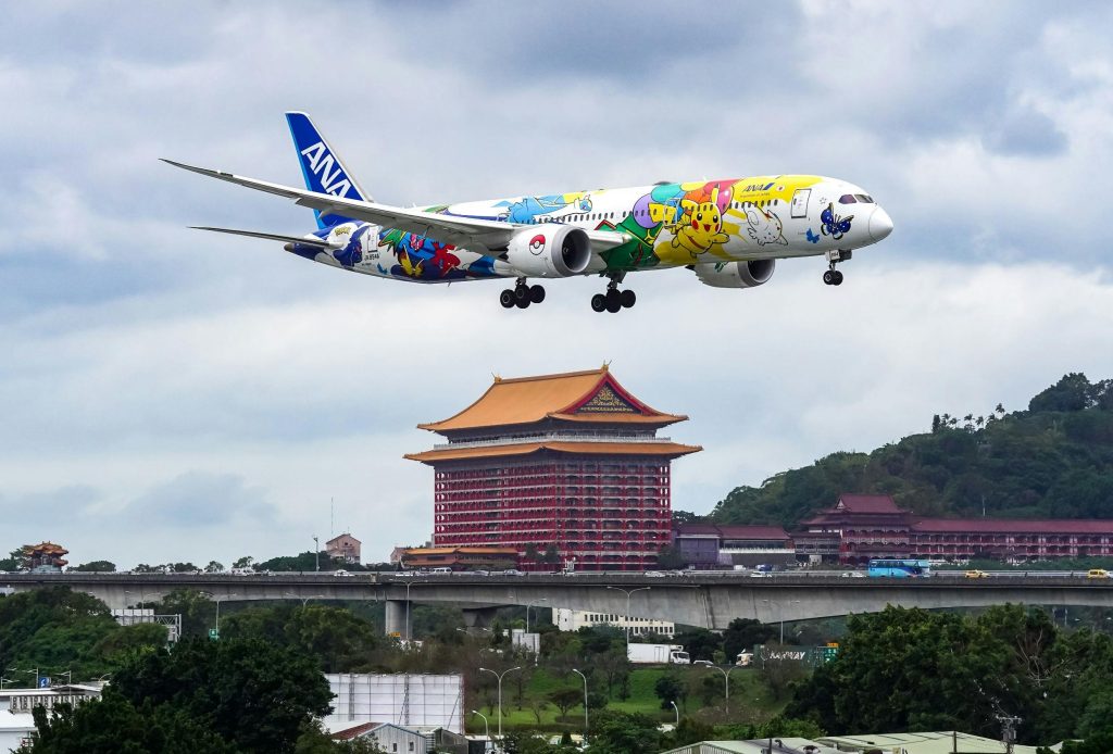 Avión aterrizando sobre una ciudad, símbolo de las emisiones del transporte aéreo.