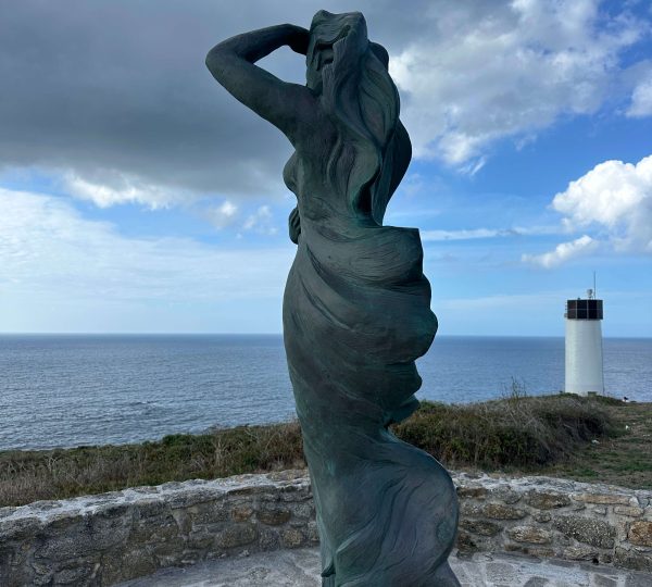 Escultura A Espera junto al Faro de Laxe y el océano Atlántico
