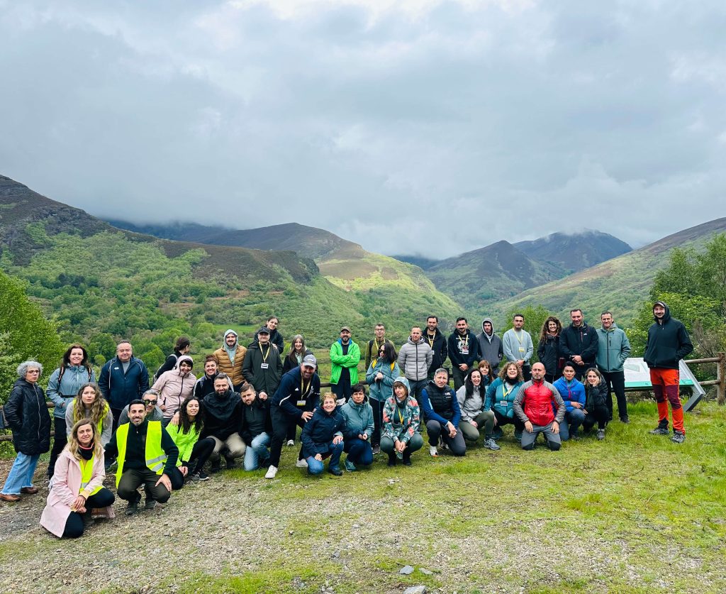 Grupo de participantes de una escapada para solteros con las montañas del Courel al fondo.