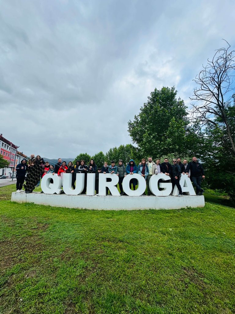 Grupo de participantes de un evento para solteros posando junto al cartel de Quiroga en Galicia.