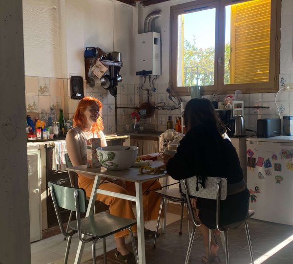 Dos residentes compartiendo desayuno en la cocina de un coliving