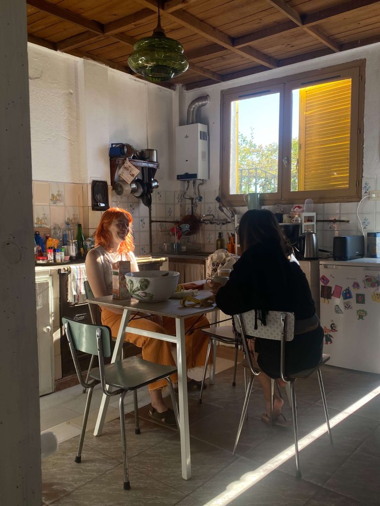Dos residentes compartiendo desayuno en la cocina de un coliving